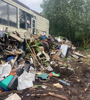 Overvolle ruimte met meubels en afval vóór ontruimingstraject door gemeente