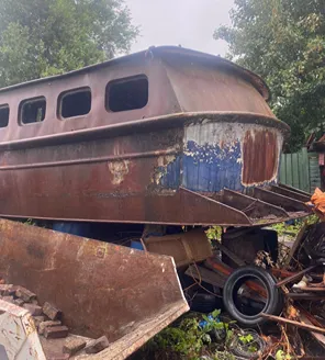 Kapotte boot en autowrakken als obstakel bij gemeentelijke terreinopruiming