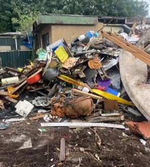 Woonwagen met rommelige erf vol afval tijdens professionele ontruiming