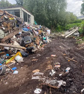 Vernield schuurtje met restanten puin en meubilair bij terreinopruiming