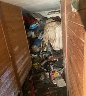 Binnenruimte volgestouwd met afval, dozen en zakken tijdens ontruiming