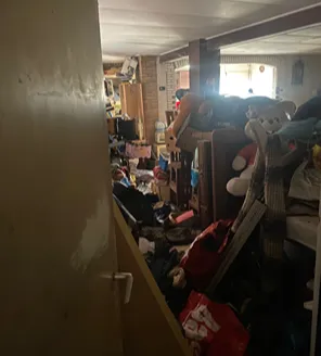 Volgestouwd interieur met speelgoed en huisraad bij extreme hoarding situatie