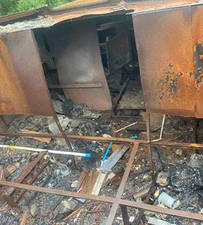 Uitgebrande metalen constructie na brand bij woningontruiming