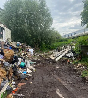 Verwaarloosd terrein met afval en puinresten na ontruiming