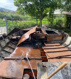 Geblakerde metalen structuur na brand tijdens ontruimingsproject