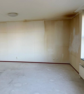 Van-gedateerde-woning-naar-instapklaar-appartement (1) Verkleurde en vervuilde woonkamerwand met nicotineaanslag vóór renovatie