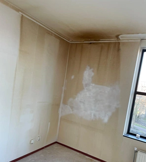 Van-gedateerde-woning-naar-instapklaar-appartement (3) Sterk vervuilde hoek met roetaanslag en herstelde plekken op de muur