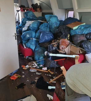 stapel met vuilniszakken in een woonkamer