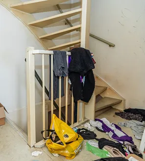 complete-transformatie-van-zwaar-vervuilde-woning-gallerij (11) Vervuilde trapopgang vol kleding en afval vóór ontruiming