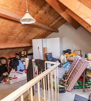 complete-transformatie-van-zwaar-vervuilde-woning-gallerij (22) Zolderruimte met opgeslagen rommel, vuilnis en kapotte meubels