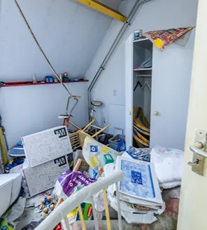 complete-transformatie-van-zwaar-vervuilde-woning-gallerij (23) Slaapkamer met dozen, losliggende spullen en kleding op de vloer