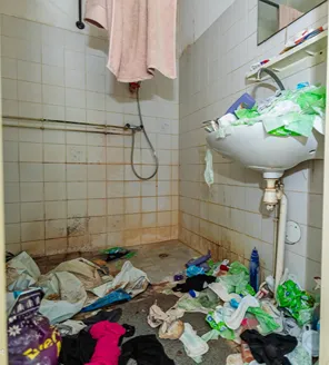 complete-transformatie-van-zwaar-vervuilde-woning-gallerij (24) Ernstig vervuilde badkamer met afval op vloer en wasbak