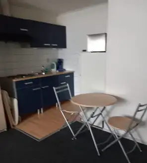 een-huis-opgeruimd-voor-een-frisse-start (2) Nette kitchenette met lege aanrechtbladen en opgeruimde tafel en stoelen.