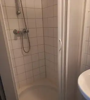 een-huis-opgeruimd-voor-een-frisse-start (3) Opgeruimde en schone badkamer met witte tegels en verzorgingsproducten netjes opgeborgen.