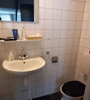 een-huis-opgeruimd-voor-een-frisse-start (4) Schone doucheruimte met witte tegels en douchekop na grondige reiniging.