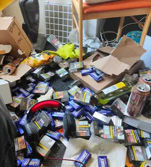 een-huis-opgeruimd-voor-een-frisse-start (5) Opgestapelde energiedrankblikken en afval in een zwaar vervuilde slaapkamer.