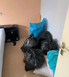 nicotine-verwijderen-en-woning-ontruimen (12) Vuilniszakken en huisraad klaargezet in kamer voor afvoer