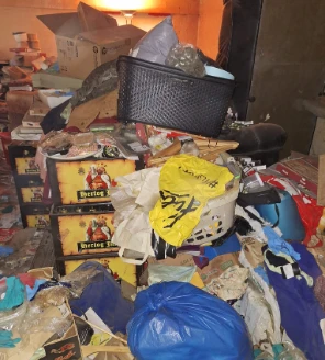 Kamerhoek volgestapeld met dozen, kleding, plastic zakken en huishoudelijke rommel