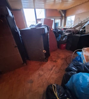 Kamer vol afvalzakken, oude meubels en ontruimde spullen bij woningvervuiling