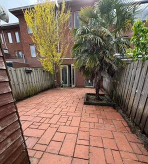 project-overwoekerde-tuin-gallerij (8) Opgeknapte tuin met schone rode tegels, zicht richting woning