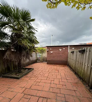 project-overwoekerde-tuin-gallerij (9) Tuin met schoon terras en dreigende lucht aan de horizon