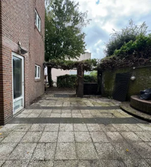 Net opgeleverd terras met schone tegels en zicht op doorgang