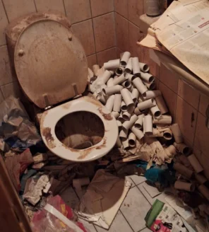 Sterk vervuild toilet vóór de woningontruiming bij verzamelwoning