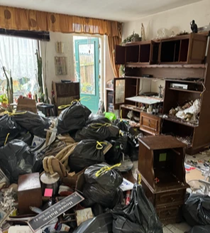 Leeggeruimde kamer met tapijt en bezem na woningontruiming