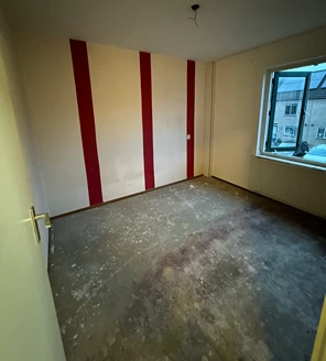 Lege slaapkamer met opvallende rood-witte muur na ontruiming