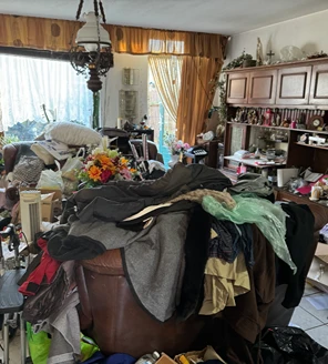 Woonkamer overvol met meubels, kleding en huisraad vóór de ontruiming