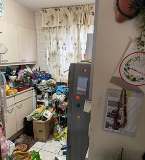 Overvolle keuken met etensresten, verpakkingen en huishoudelijk afval vóór ontruiming